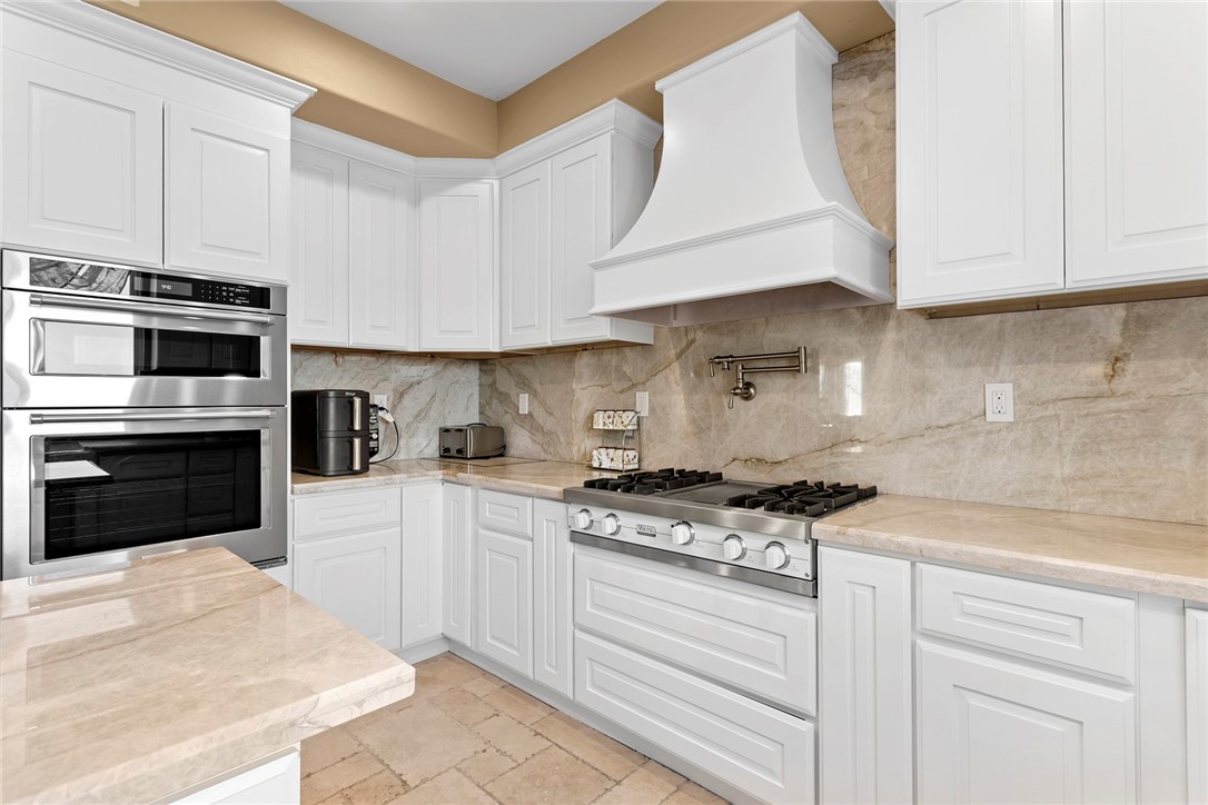 26403 Ocasey Place Stevenson Ranch, CA 91381 - Photo 8 of 27 a kitchen with granite countertop a stove a sink and a microwave