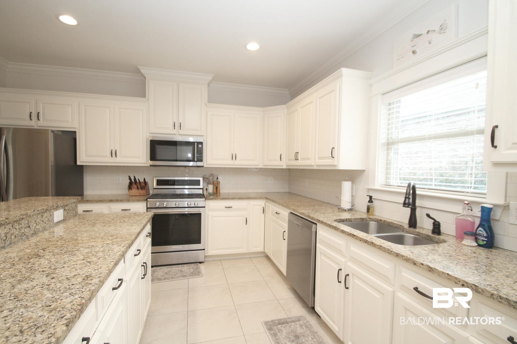30232 Persimmon Drive Daphne, AL 36527 - Photo 6 of 27 Kitchen featuring light stone counters, stainless steel appliances, tasteful backsplash, white cabinets, and a sink