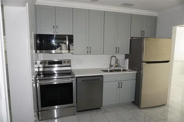 a kitchen with a refrigerator sink and cabinets