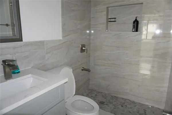 a bathroom with a sink a toilet and shower