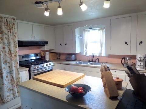 631 Ranck Avenue Mason, TX 76856 - Photo 6 of 17 a kitchen with a sink a stove and a wooden cabinets