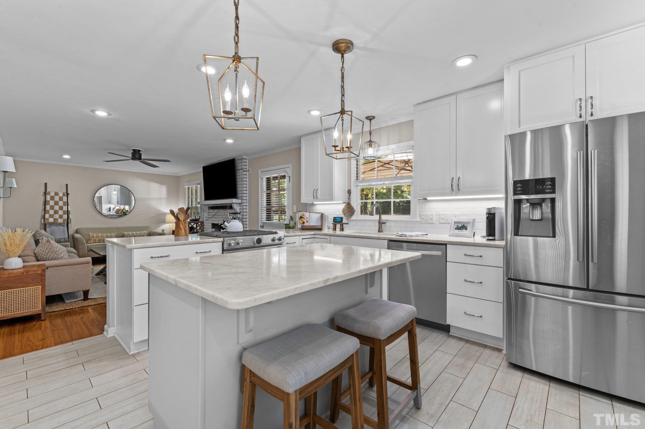 6704 Valley Drive Raleigh, NC 27612 - Photo 16 of 39 a kitchen with stainless steel appliances kitchen island granite countertop a table chairs and a sink