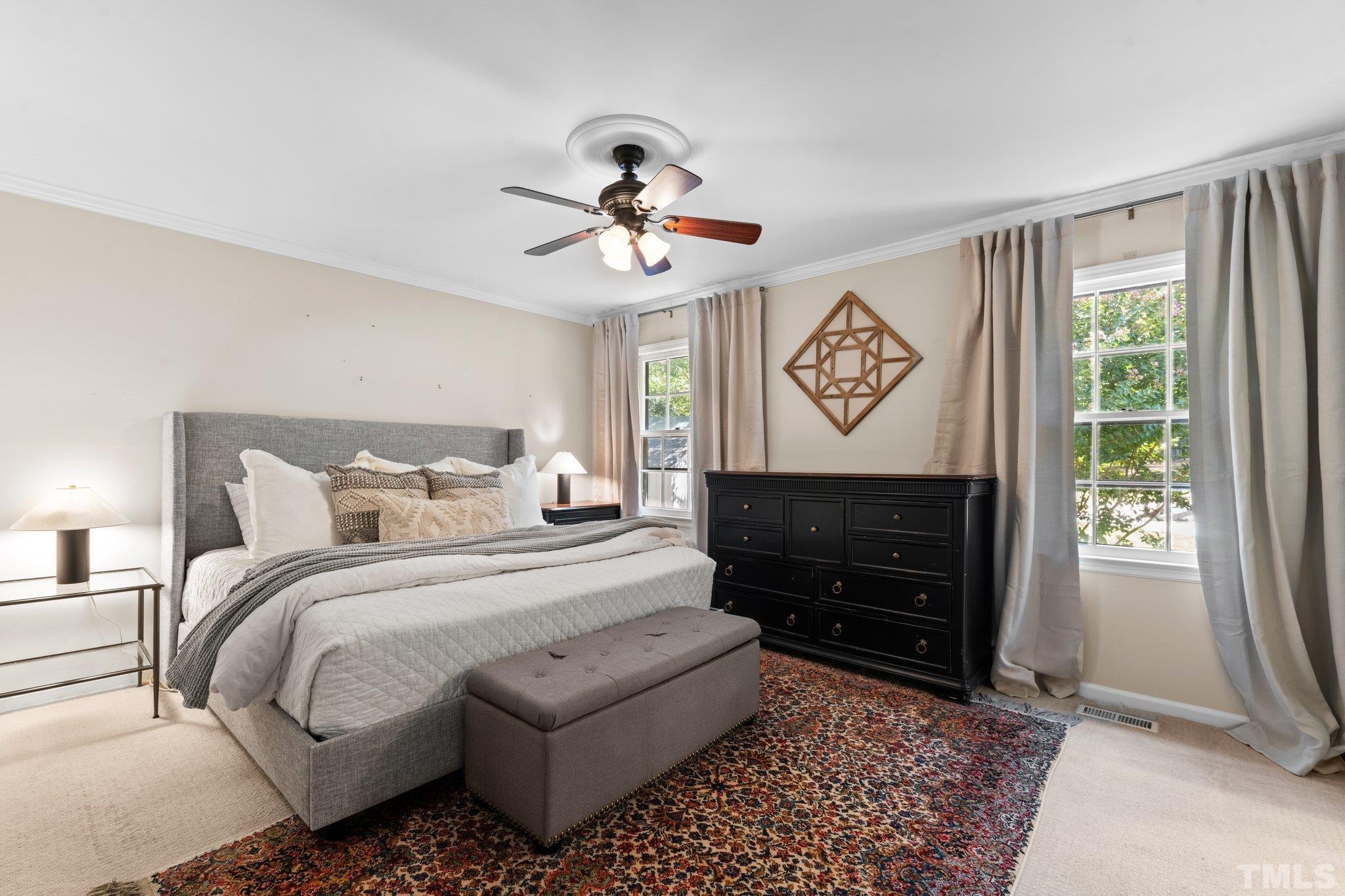 6704 Valley Drive Raleigh, NC 27612 - Photo 20 of 39 a bedroom with a bed and a chandelier