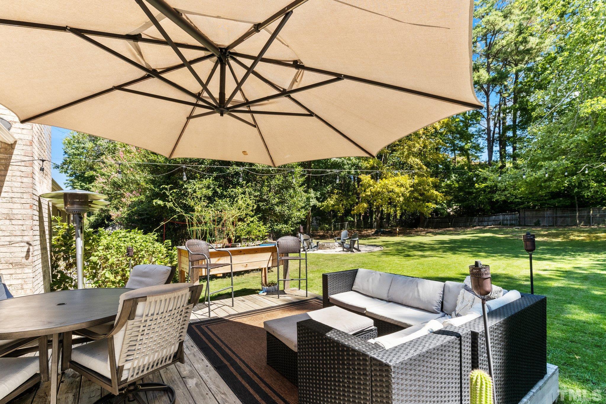 6704 Valley Drive Raleigh, NC 27612 - Photo 30 of 39 a view of a patio with couches chairs under an umbrella