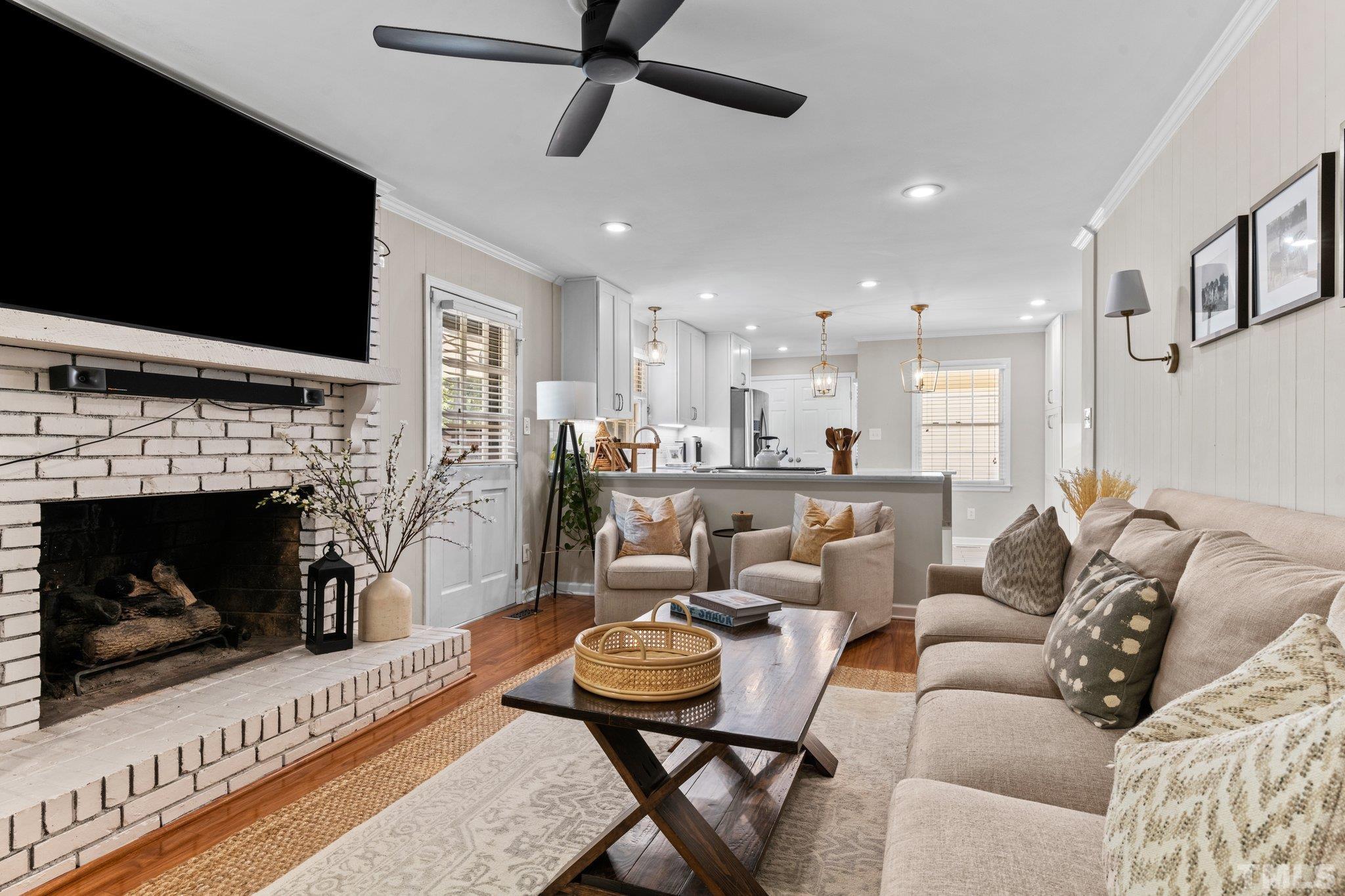 6704 Valley Drive Raleigh, NC 27612 - Photo 7 of 39 a living room with furniture a flat screen tv and a fireplace