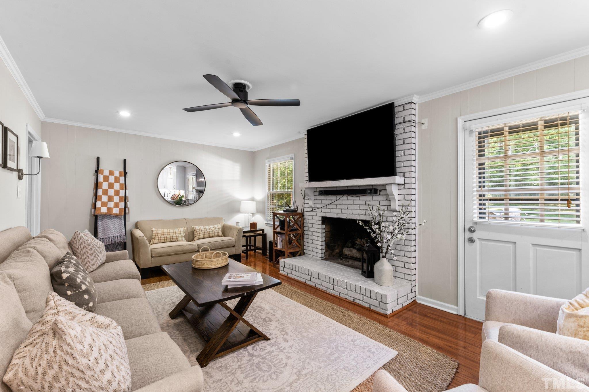 6704 Valley Drive Raleigh, NC 27612 - Photo 9 of 39 a living room with furniture a fireplace and a flat screen tv
