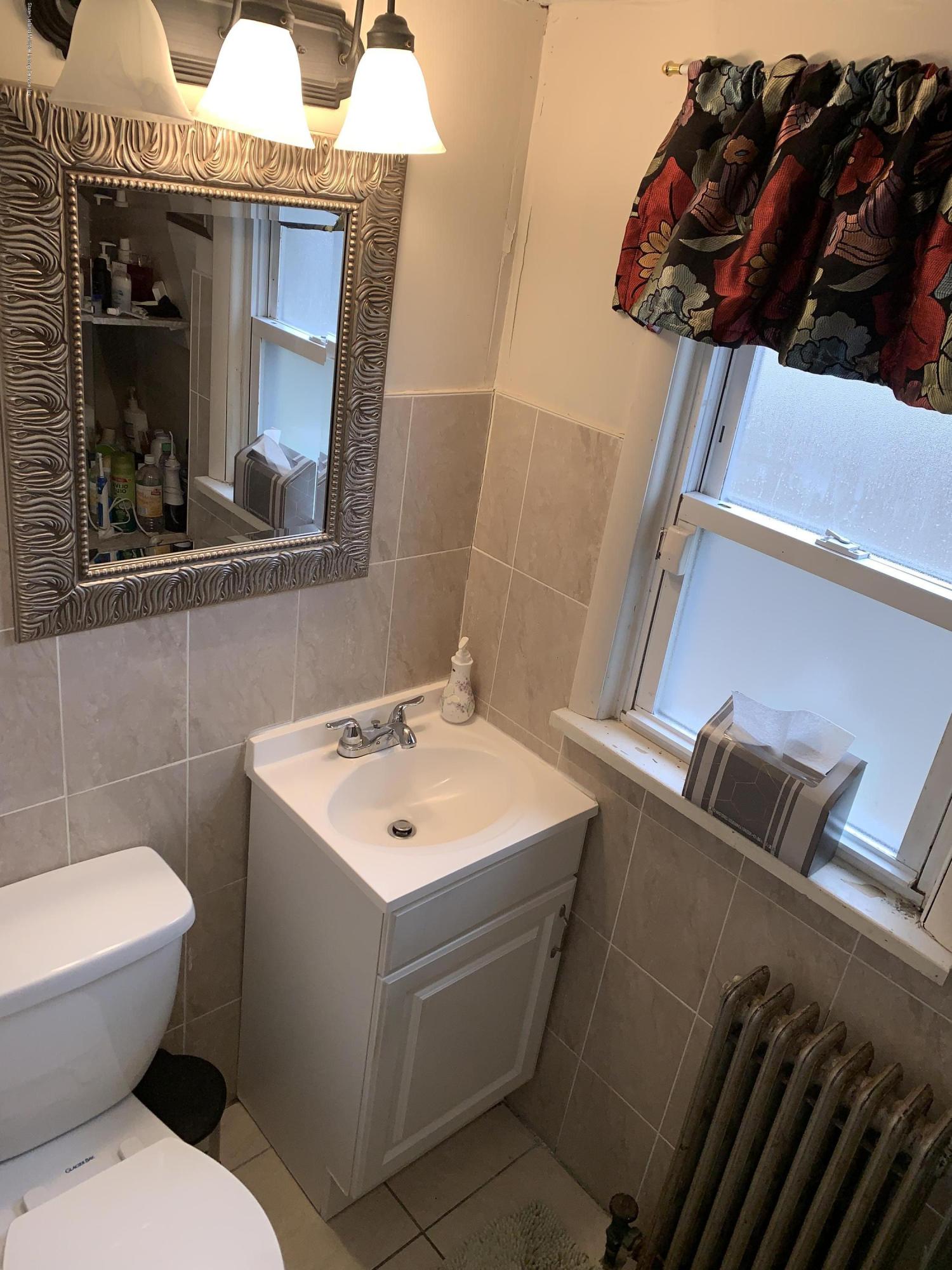 7 Lockman Place Staten Island, NY 10303 - Photo 11 of 41 a bathroom with a toilet a sink and mirror