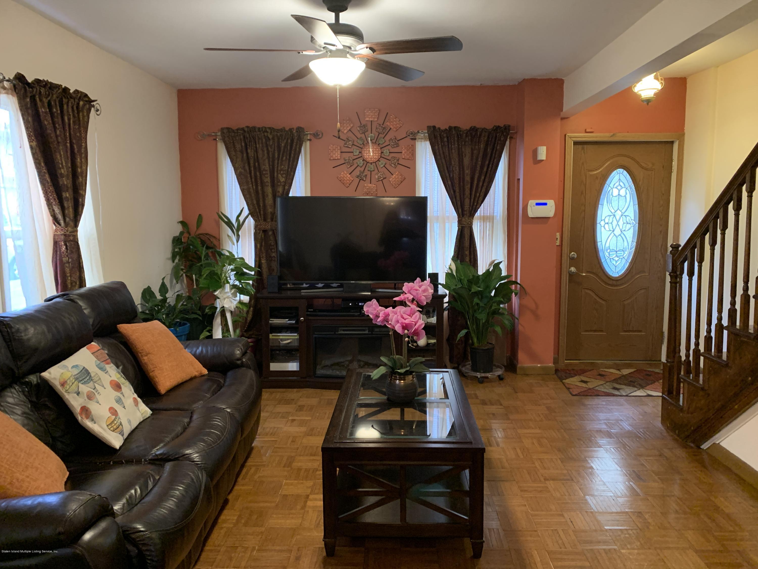 7 Lockman Place Staten Island, NY 10303 - Photo 33 of 41 a living room with furniture a flat screen tv and a fireplace