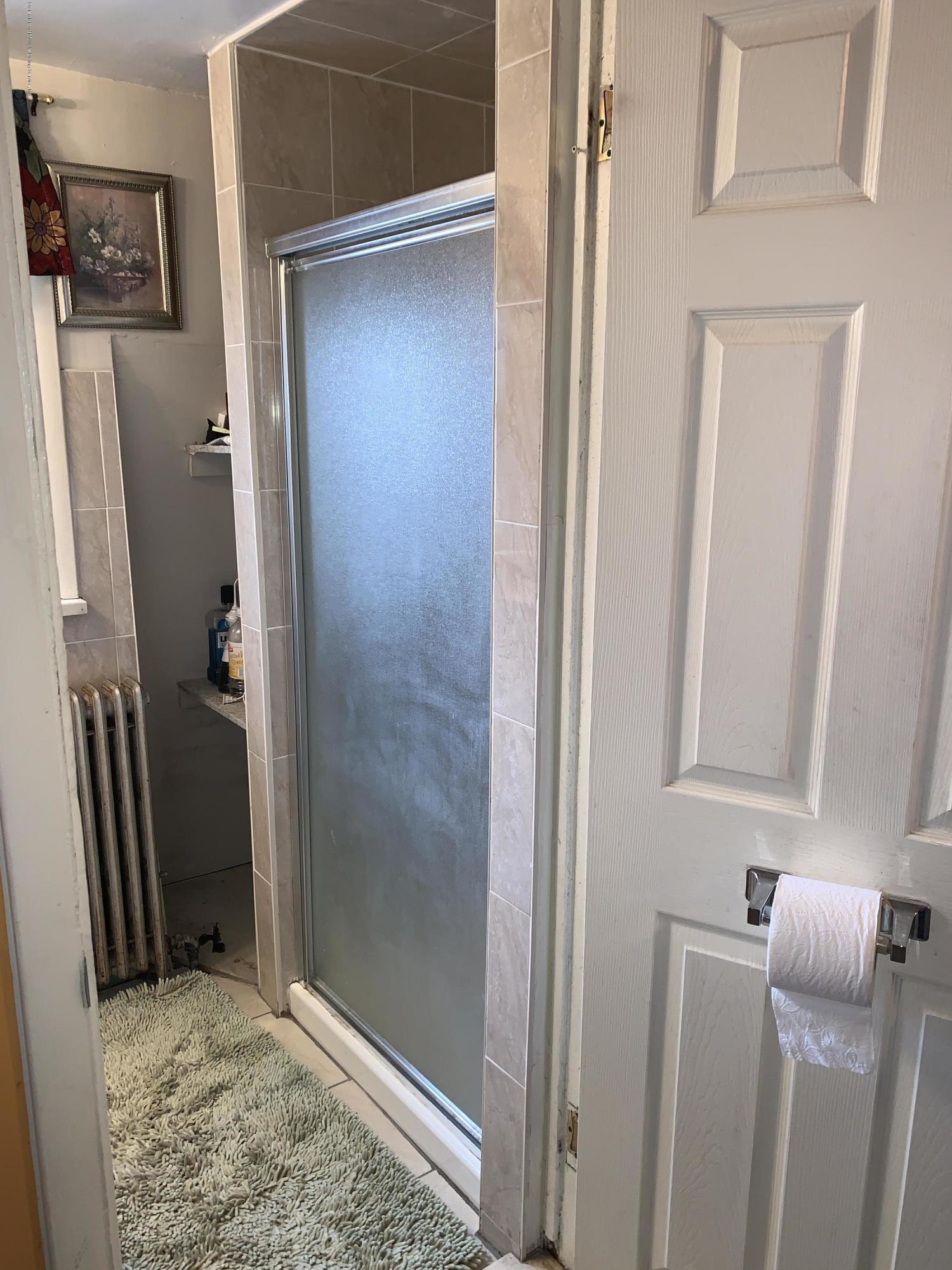 7 Lockman Place Staten Island, NY 10303 - Photo 10 of 41 a bathroom with a granite countertop shower and a sink