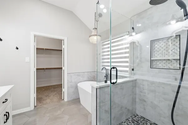 a bathroom with a double vanity sink mirror and bathtub
