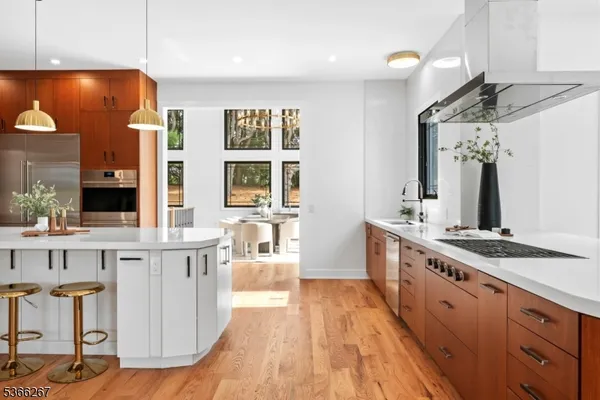 a living room with stainless steel appliances kitchen island granite countertop a refrigerator a stove top oven a sink and dishwasher