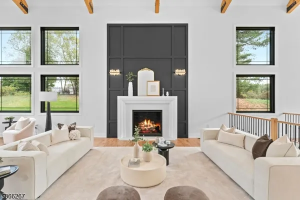 a living room with furniture a fireplace and a floor to ceiling window