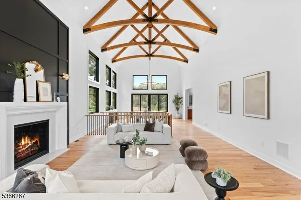a dining room with wooden floor a chandelier a glass table and windows