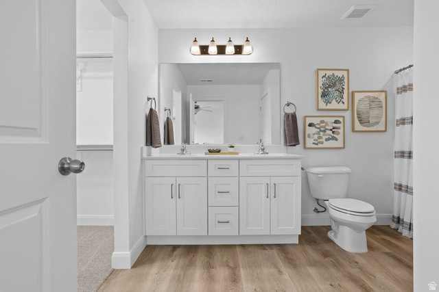 488 West Greenstone Pl Street, Unit 1010 St. George, UT 84790 - Photo 25 of 34 Dual sink vanity with white cabinetry, a large mirror, and overhead lighting