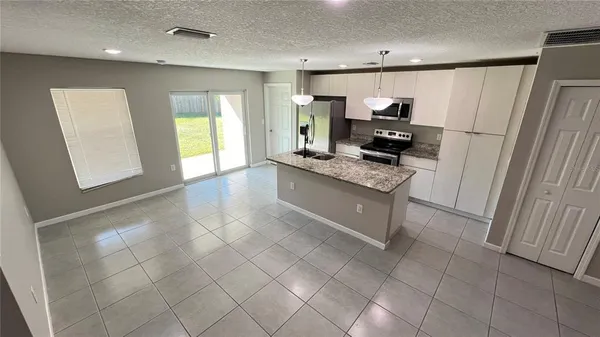 a kitchen with kitchen island granite countertop a stove a sink and a refrigerator