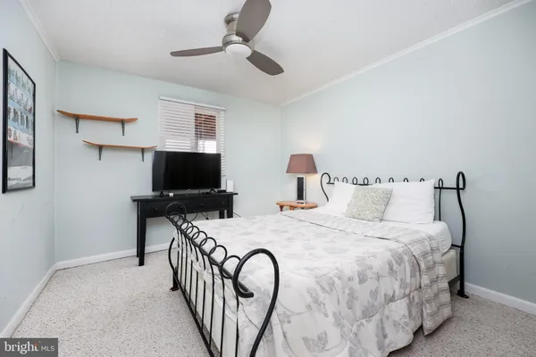 a bedroom with bed and a flat tv screen on dresser