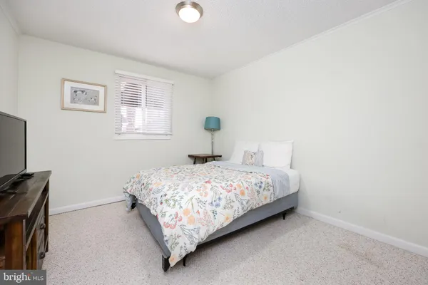 a bedroom with a bed and a flat tv screen on a dresser