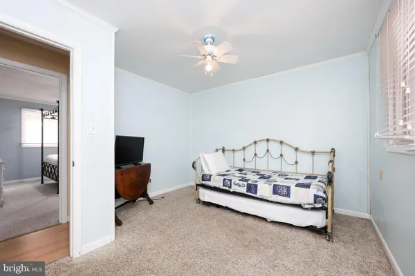 a bed sitting in a spacious bedroom next to a window and a chandelier