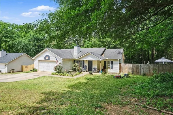 a front view of a house with a yard and trees