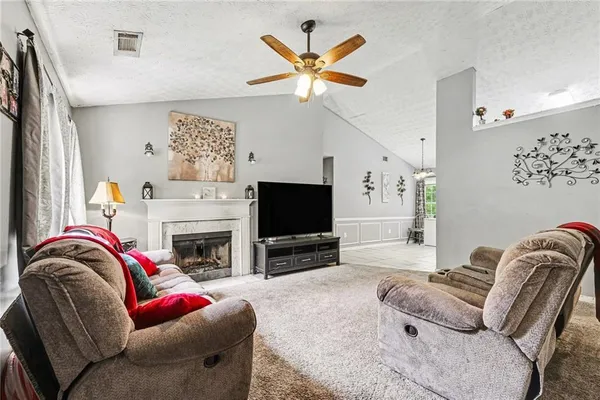 a living room with furniture a flat screen tv and a fireplace