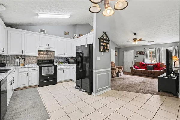 a kitchen with granite countertop a refrigerator oven a sink dishwasher and a stove with a dining table