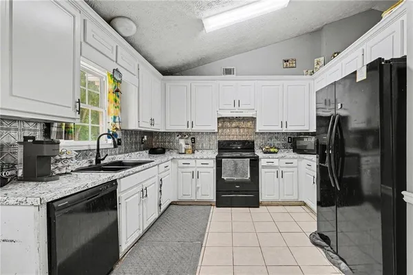 a kitchen with stainless steel appliances granite countertop a refrigerator sink and cabinets