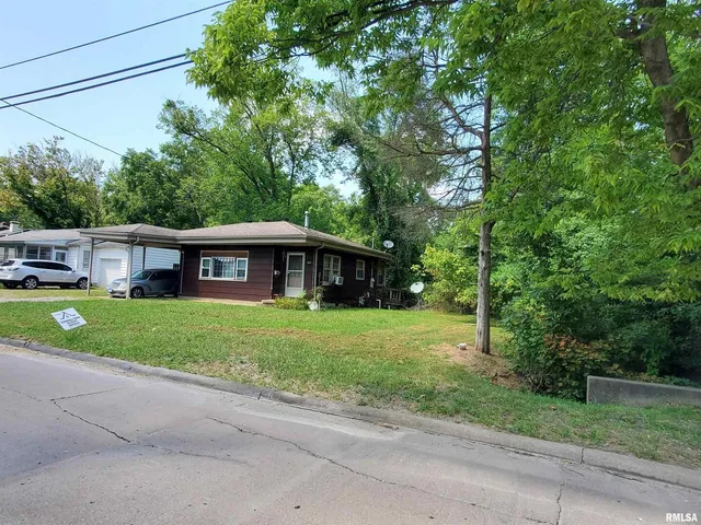 a front view of a house with a yard and trees