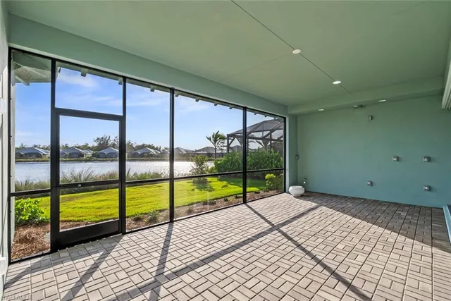 a view of an empty room with wooden floor and windows