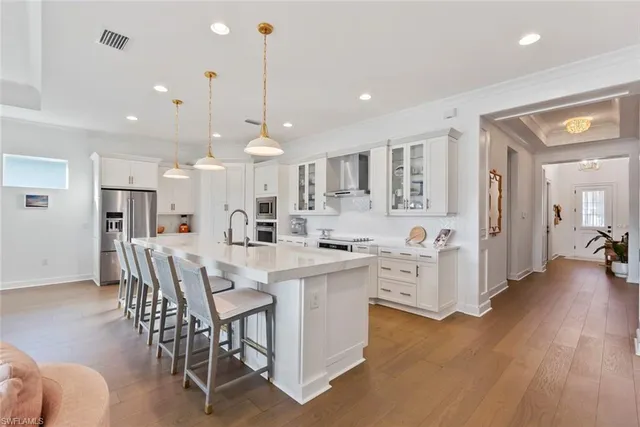 a kitchen with stainless steel appliances kitchen island granite countertop a table chairs and a refrigerator