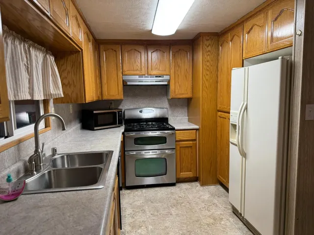 a kitchen with a refrigerator sink and cabinets