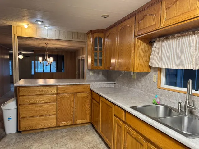 a kitchen with stainless steel appliances granite countertop a sink and dishwasher a stove with wooden cabinets