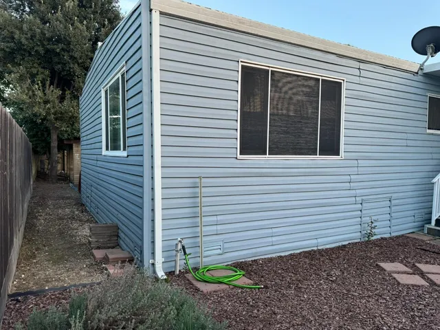 a view of a house with backyard and a trees