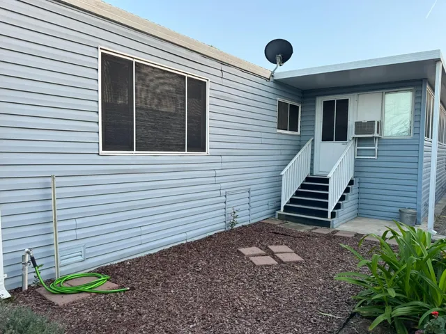 a view of a house with a yard and wooden fence