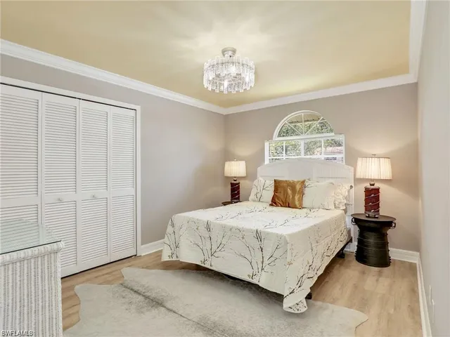 a bedroom with a bed and a chandelier