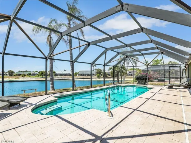 a view of a swimming pool with a patio and a backyard