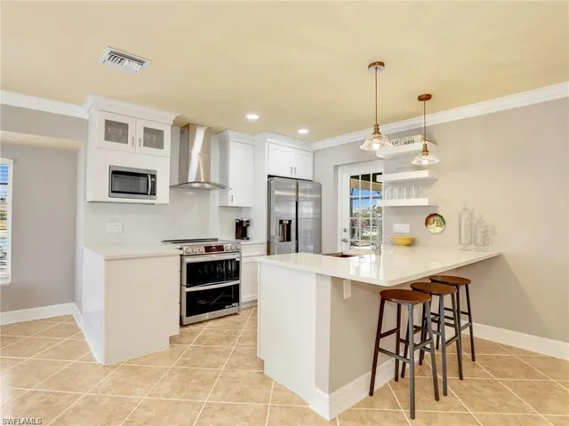 a kitchen with kitchen island a stove a table and chairs in it