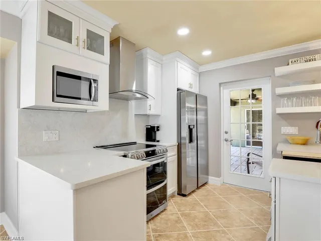 a kitchen with stainless steel appliances a refrigerator a stove a sink and a refrigerator