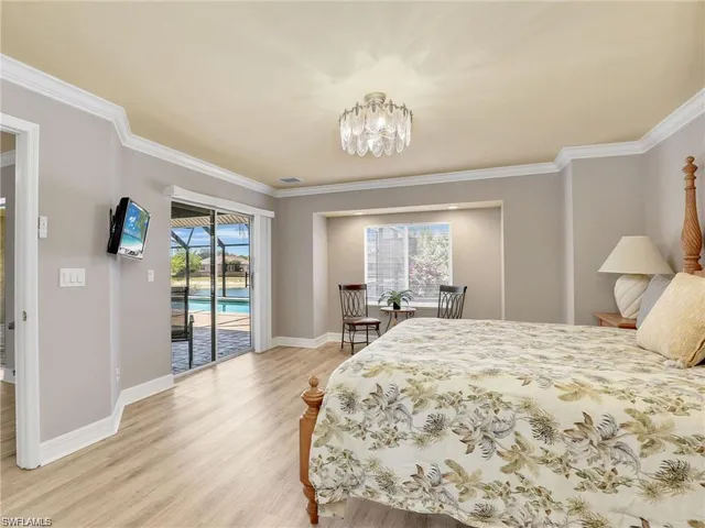 a bedroom with a large bed and a chandelier