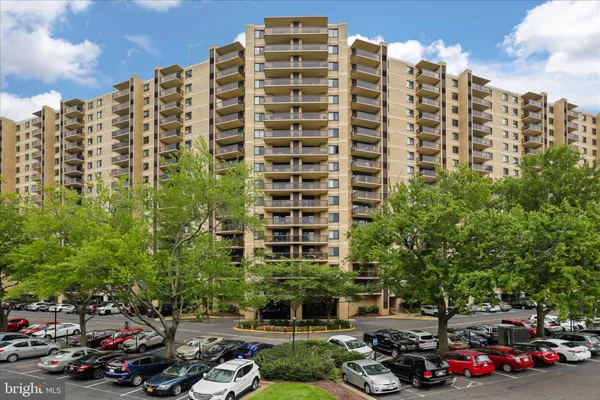 a front view of a building with lot of cars parked