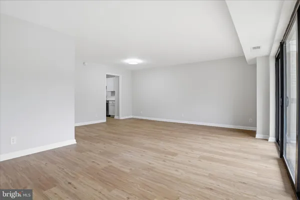 a view of empty room with wooden floor and window