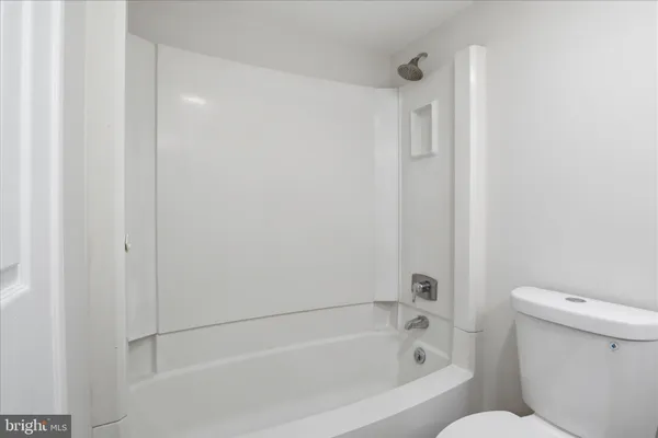 a white bath tub sitting next to a toilet