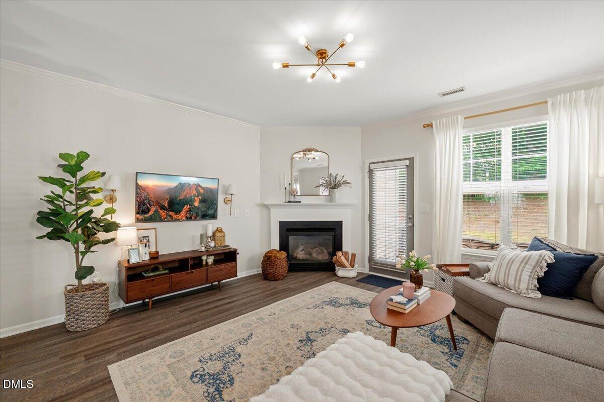 8449 Central Drive Raleigh, NC 27613 - Photo 11 of 38 a living room with furniture a fireplace and a potted plant