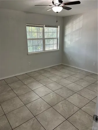 an empty room with windows and ceiling fan
