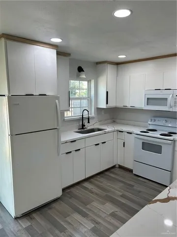 a kitchen with granite countertop cabinets appliances a sink and a window