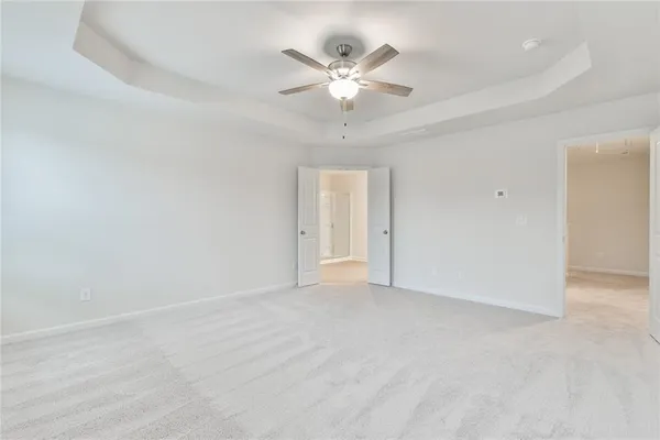 wooden floor in white room with a ceiling fan and window