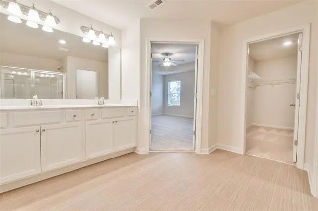 a bathroom with a double vanity sink a mirror and a shower