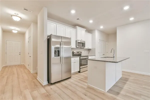 a kitchen with stainless steel appliances a refrigerator and a stove top oven