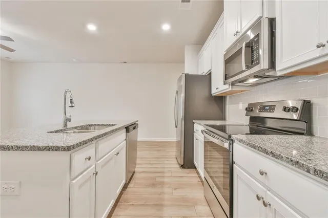 a kitchen with stainless steel appliances granite countertop a sink and stove