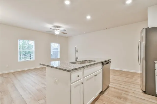 a kitchen with stainless steel appliances granite countertop a sink and a refrigerator
