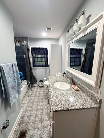 a bathroom with a granite countertop sink a mirror and vanity